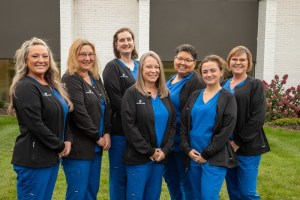 Group photo of staff outside on lawn in uniform scrubs